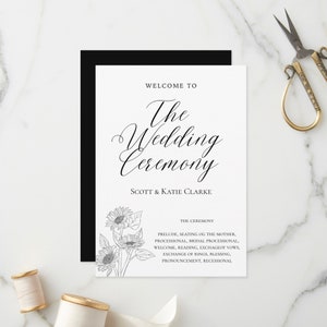 May include: A black and white wedding ceremony order of service with a simple design. The order of service features a floral illustration of sunflowers and the text "Welcome to The Wedding Ceremony Scott & Katie Clarke". The ceremony details are listed below the couple's names.