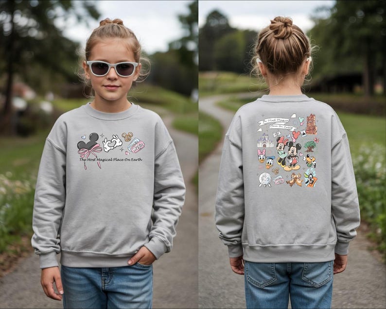 以下が含まれることがあります： ミッキーマウスと他のディズニーキャラクターが描かれたグレーのスウェットシャツ。「The Most Magical Place On Earth」の文字とミッキーマウスの耳、白いウサギなどのグラフィックが前面にプリントされています。背面には、ディズニーキャラクターの大きなグラフィックがあります。