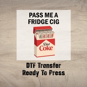 May include: A graphic featuring a Diet Coke cigarette pack with the text "PASS ME A FRIDGE CIG." The pack is red and white, with "Diet Coke" branding. The text "DTF Transfer Ready To Press" is below.
