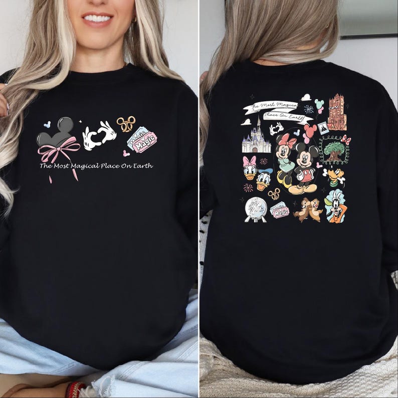 以下が含まれることがあります： ミッキーマウスの耳、ハートを作る手、そして「Magic」と書かれたチケットが描かれた黒いスウェットシャツ。「The Most Magical Place On Earth」の文字が前面にプリントされています。背面には、さまざまなディズニーキャラクターのイラストがあります。