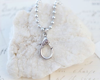May include: Silver chain necklace with a silver lobster clasp. The chain is made of small, round beads.
