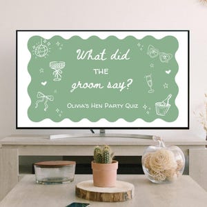 Puede incluir: Una pantalla de televisión muestra un letrero verde con texto e ilustraciones en blanco. El letrero dice: "¿Qué dijo el novio? Olivia's Hen Party Quiz". Las ilustraciones incluyen una bola de discoteca, una copa de champán y gafas de sol.