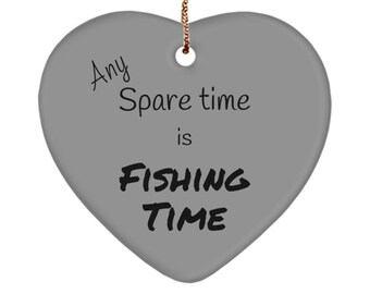 Op de afbeelding: Een grijs hartvormig ornament met de tekst "Any Spare time is FISHING TIME" in zwart. Het ornament is opgehangen aan een goudkleurig touwtje. Een decoratief item voor visliefhebbers.