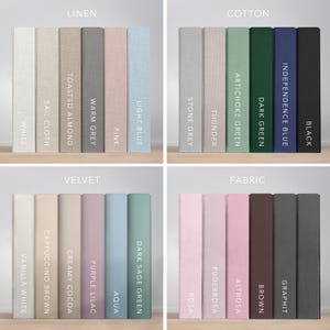 May include: A selection of fabric samples in a range of colours, from white and pink to blue and black. Each swatch is labelled with its colour name, like "White," "Pink," and "Black." The samples are neatly arranged, displaying diverse textures and materials.