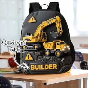 May include: Black backpack featuring a yellow excavator and dump truck design. The backpack has the word "BUILDER" in yellow letters. Includes a warning sign graphic and the words "Custom Text".