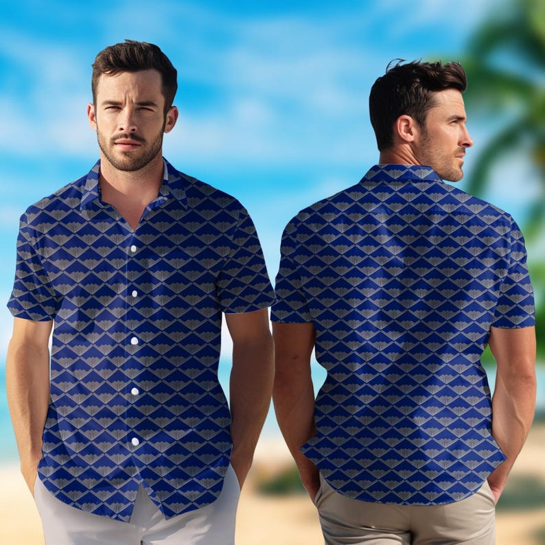 Puede incluir: Una camisa de manga corta con un patr&oacute;n geom&eacute;trico azul y gris. La camisa se muestra por delante y por detr&aacute;s, con un cielo azul y palmeras de fondo. La camisa tiene un cuello cl&aacute;sico y botones blancos.