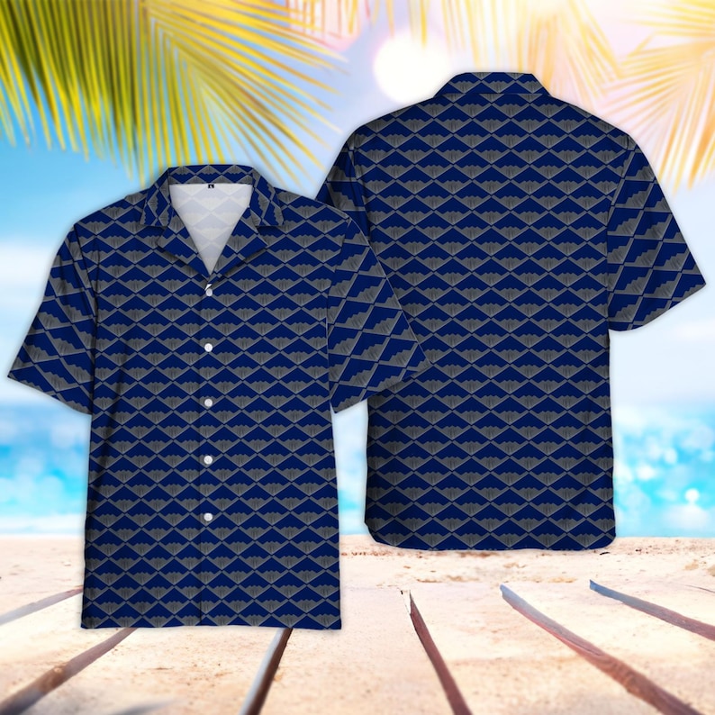 Puede incluir: Una camisa de manga corta con fondo azul marino y un patr&oacute;n geom&eacute;trico gris repetido. La camisa tiene un cuello cl&aacute;sico y botones blancos. La imagen muestra la parte delantera y trasera de la camisa.