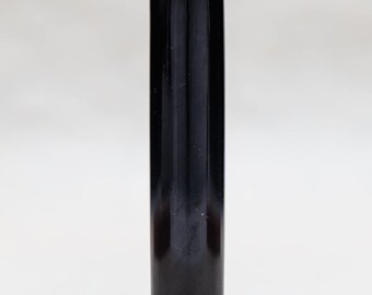 May include: A black, cylindrical, polished, ink stamp with a rounded top.