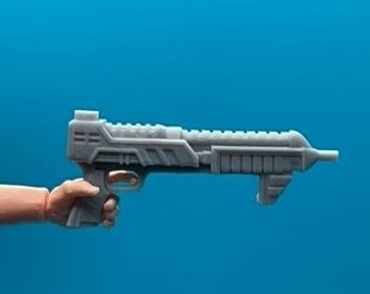 May include: A gray plastic toy gun with a futuristic design. The gun has a black handle and a silver barrel.