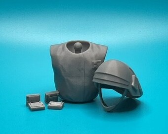 May include: A gray miniature military figure set on a blue background. The set includes a torso, a helmet, and several small rectangular objects. The helmet has a visor and chin strap. The torso has a high collar and a small pocket.