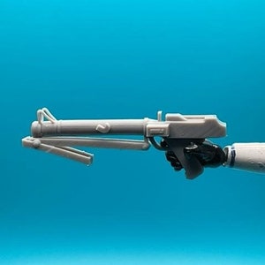 May include: A white plastic toy blaster with a black handle. The blaster has a long barrel and a small scope.