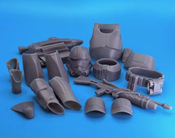 Könnte beinhalten: Eine Sammlung grauer Kunststoff-Star-Wars-Rüstungs- und Waffenteile, darunter ein Helm, ein Brustpanzer, ein Gürtel, Bein- und Armteile, zwei Hüte und zwei Blaster. Die Artikel sind auf blauem Hintergrund angeordnet.