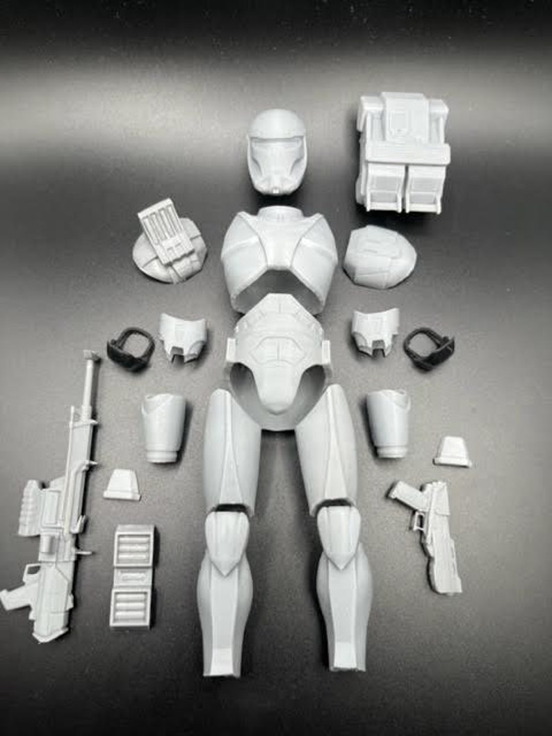 Puede incluir: Un conjunto de piezas de pl&aacute;stico impresas en 3D para un modelo de soldado clon de Star Wars. El conjunto incluye el casco, el torso, las piernas, los brazos y las armas.