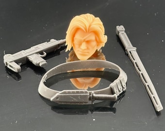 May include: A collection of action figure accessories, including a light gray Uzi submachine gun, a light gray sword, and a light gray belt. A blonde-haired head with a scar over one eye is also included.