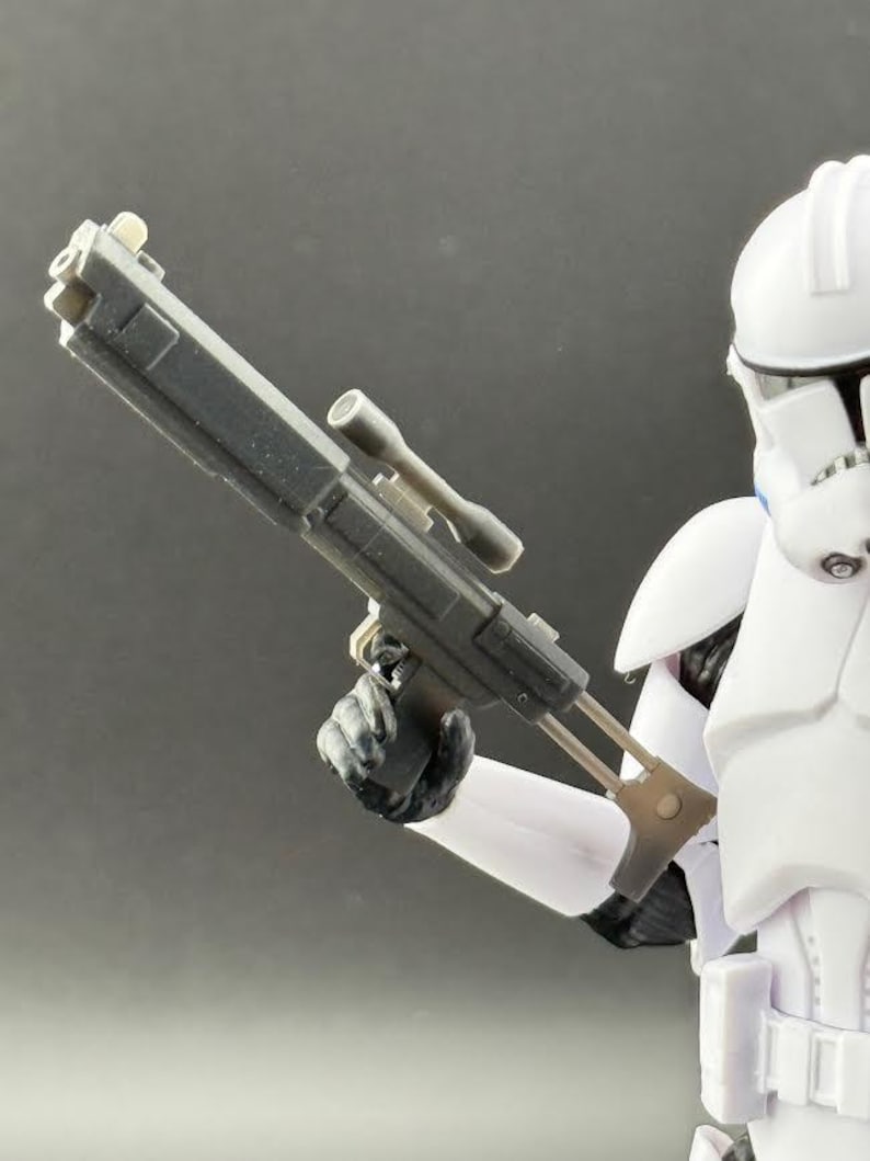 May include: A black plastic blaster with a scope and a white Stormtrooper action figure holding the blaster.