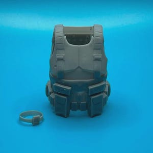 Peut inclure: Un gilet tactique gris avec plusieurs poches et sangles. Une ceinture en plastique grise est &eacute;galement incluse.