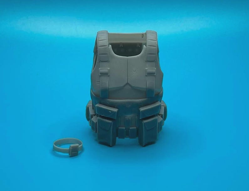 Peut inclure: Un gilet tactique gris avec plusieurs poches et sangles. Une ceinture en plastique grise est &eacute;galement incluse.
