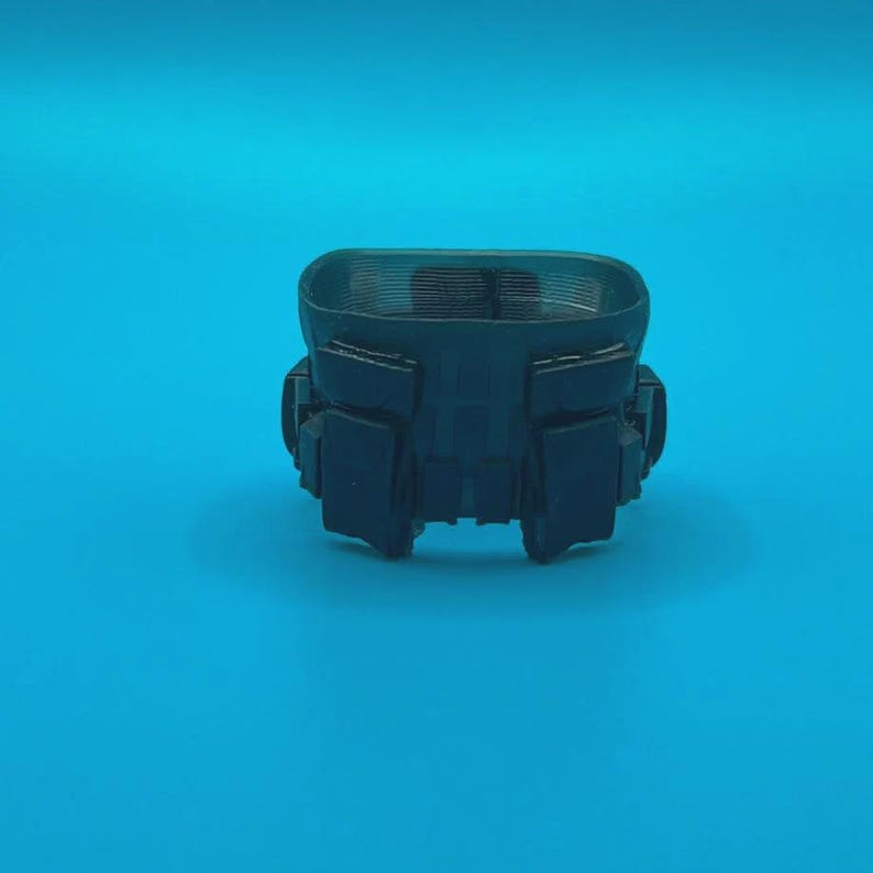 Peut inclure: Une ceinture tactique en plastique noir avec plusieurs pochettes et un dessus textur&eacute;.