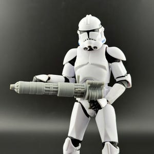 Peut inclure: Figurine blanche repr&eacute;sentant un soldat en armure, tenant une arme grise. La figurine a un casque et des d&eacute;tails noirs. Le fond est gris fonc&eacute; uni.