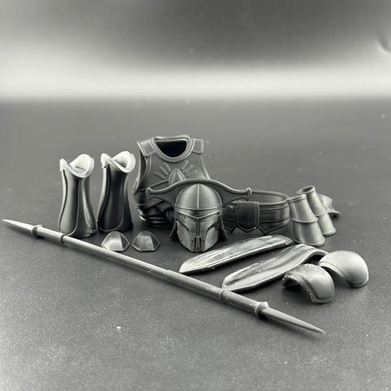 K&ouml;nnte beinhalten: Eine Sammlung grauer Kunststoff-R&uuml;stungsteile, darunter ein Helm, eine Brustplatte, ein G&uuml;rtel, Schulterpolster und ein Speer. Das Set scheint f&uuml;r eine Figur oder ein Cosplay zu sein, mit detaillierten Formdesigns.