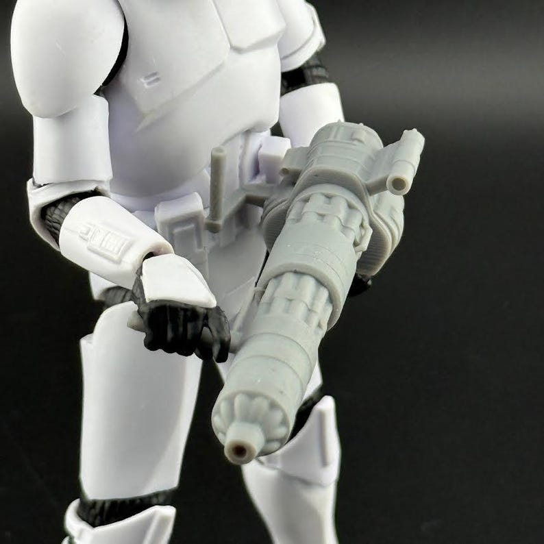 Peut inclure: Figurine d'un Stormtrooper de Star Wars blanc tenant une arme blaster grise. La figurine porte une armure blanche avec des d&eacute;tails noirs. Le blaster est cylindrique avec des &eacute;l&eacute;ments m&eacute;caniques d&eacute;taill&eacute;s.