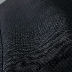 Puede incluir: Primer plano de una tela gris oscura con un tejido texturizado.