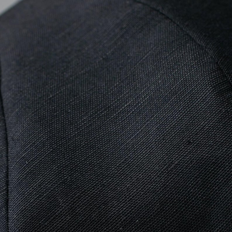 Puede incluir: Primer plano de una tela gris oscura con un tejido texturizado.