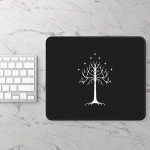 May include: Black mouse pad with a white outline and a white stylized tree with stars in the canopy.
