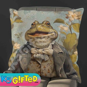 May include: A decorative throw pillow featuring a whimsical illustration of a frog wearing a waistcoat and bow tie. The frog is set against a background of blue and green floral patterns.