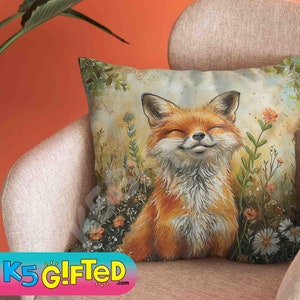 May include: A throw pillow with a smiling fox illustration surrounded by flowers. The fox is orange and white with a brown nose and black eyes. The background is a light brown with green leaves and flowers.
