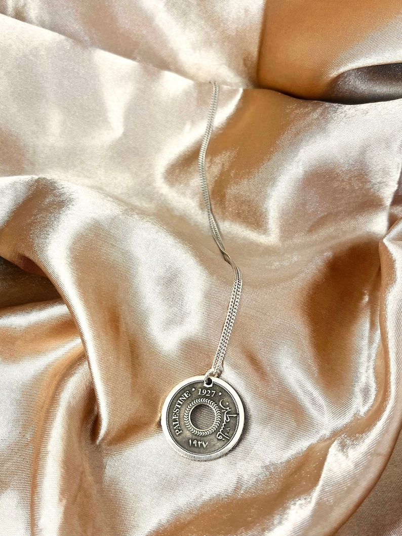 This piece represents the 1927 10 or 5 Mil coin. (Double-sided coin). Can be worn on both sides!
Handmade in Palestine of high quality sterling silver.