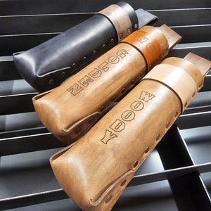 Pu&ograve; includere: Tre portautensili in pelle con diversi colori di pelle e nomi personalizzati. I nomi sono "WOOD", "ZUCKER" e "W.G."