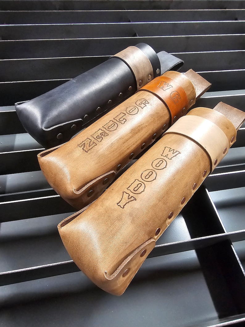 Pu&ograve; includere: Tre portautensili in pelle con diversi colori di pelle e nomi personalizzati. I nomi sono "WOOD", "ZUCKER" e "W.G."