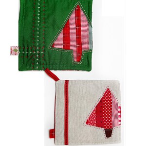 May include: Two handmade Christmas tree pot holders. One is green with a red and white plaid tree. The other is beige with a red, white, and pink polka dot tree.