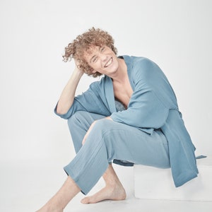 Model wearing a ble loungewear set, consisting of a wrap-style top with a side tie and three-quarter length sleeves, paired with comfortable, cropped pants.