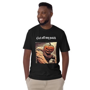 Może przedstawiać: Czarny T-shirt z grafiką przedstawiającą postać z głową dyni z nadrukiem "Get off my patch" na przodzie.
