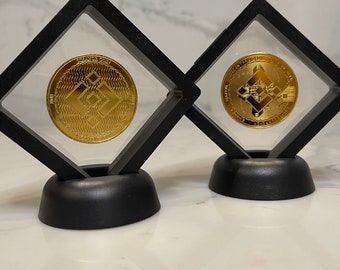 Può includere: Due monete di criptovaluta dorate in teche nere. Le monete presentano il logo di Ethereum e il testo "Ethereum" e "Cryptocurrency".