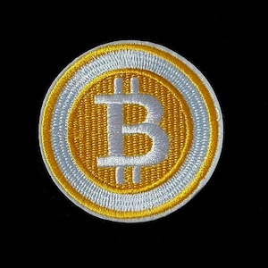 May include: A white and gold embroidered patch with the Bitcoin symbol in the centre.