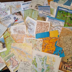 May include: A collection of vintage maps and travel guides, including maps of California, Central America, Scotland, Boston, and Ireland. The maps are in various colors and styles, and some have text on them.