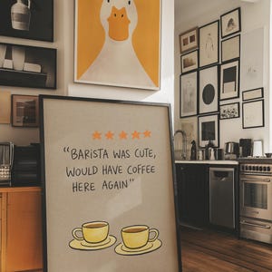 May include: A white ceramic mug with a black handle and the text "But First, Coffee" in a bold, black font. The mug is set against a blurred background, suggesting a cozy setting.