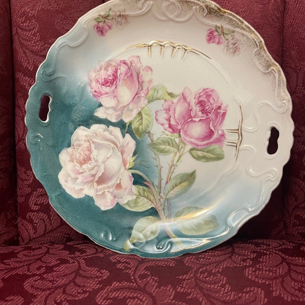 Antiker jährlicher 1900er bayrischer Servier- / Kuchenteller ”Roses ”Durchmesser 9 cm mit Griffen und gezackten Kanten .Handbemalt.Sehr guter Zustand.
