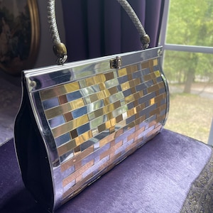 Bolso de mano de metal tejido único y raro de la década de 1950-1960 de 10" de largo, 6,5" de alto y 3" de ancho. Presenta un llamativo tono plateado y dorado. Una pieza llamativa.