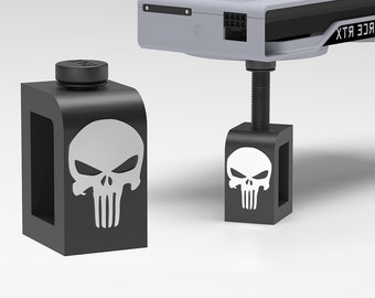 Pode incluir: Dois elevadores de plástico preto com um gráfico de caveira branca são usados para apoiar uma placa gráfica GeForce RTX 3090 branca e preta.