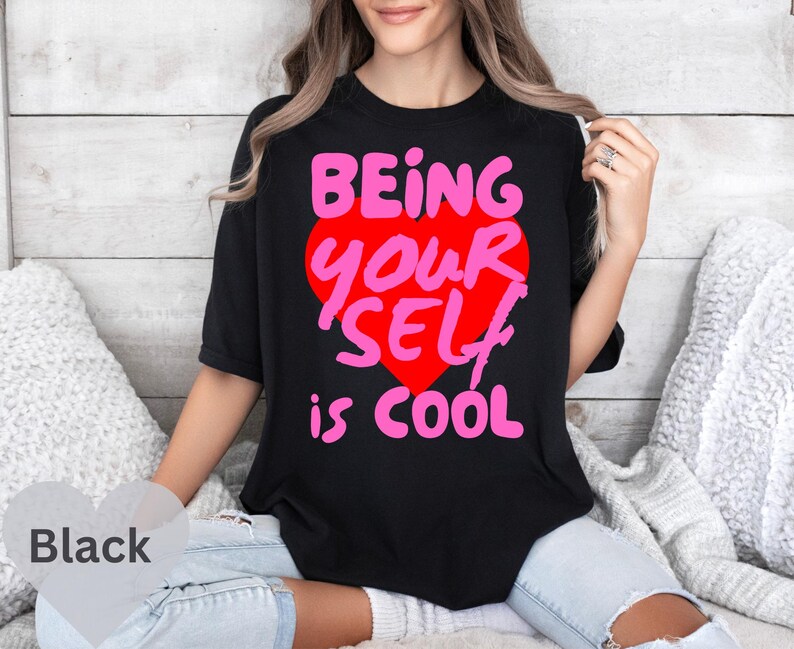 May include: Black t-shirt with a pink heart graphic and the text "Being Your Self is Cool".
