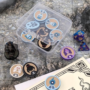 Puede incluir: Una colección de accesorios para juegos de mesa, que incluye fichas, dados y una figura en miniatura. Las fichas presentan varios diseños y números. Un recipiente de plástico transparente contiene algunas de las fichas. Los dados son azules y morados.
