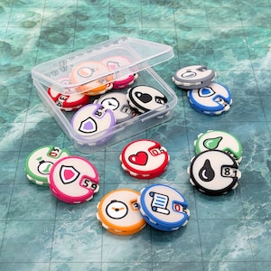 May include: A clear plastic storage box containing several round, multi-colored game tokens with rotating number dials. Each token features a unique icon, including a red heart, a blue shield, a green potion, and a scroll, with numbers displayed on the side.