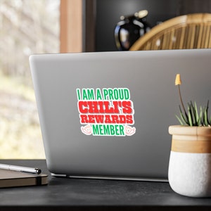 May include: A laptop computer with a sticker that says "I am a proud Chili's Rewards Member" in green and red text with chili pepper graphics.