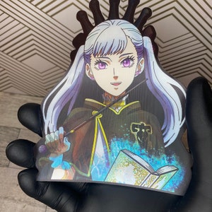 May include: A white-haired anime character with purple eyes, wearing a black and gold robe, holding a staff and a book with blue magic swirling around it.
