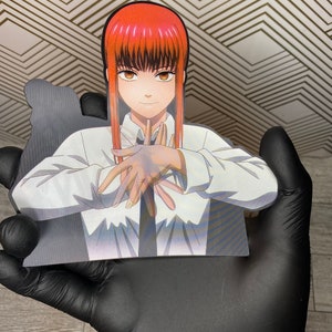 May include: A white shirt with a black tie, worn by a woman with long red hair and brown eyes. She is holding her hands in front of her, with her fingers interlocked.