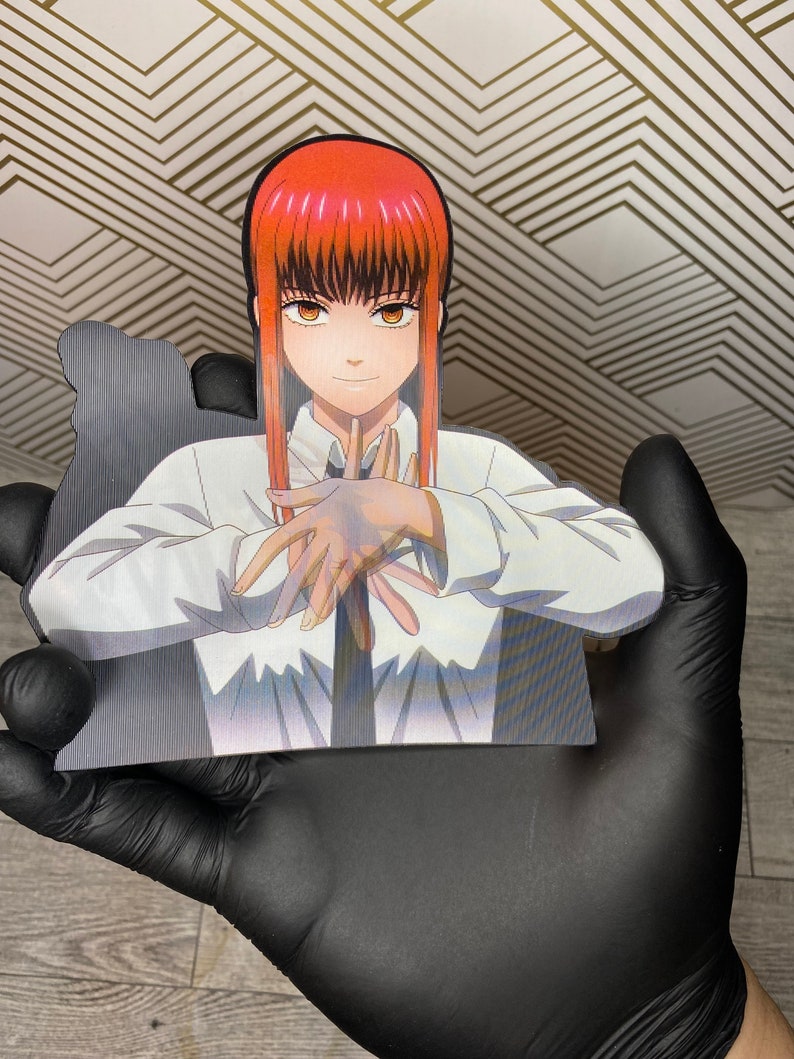 May include: A white shirt with a black tie, worn by a woman with long red hair and brown eyes. She is holding her hands in front of her, with her fingers interlocked.